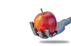 A robot hand holding an apple.