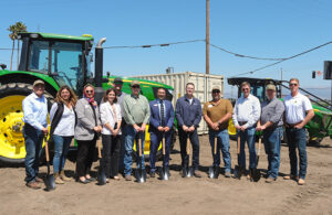group of people in front of several tractors.