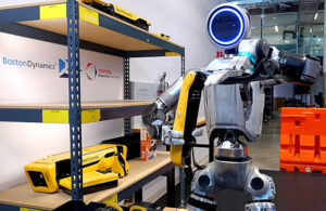 An Atlas robot handling a Spot quadruped leg.