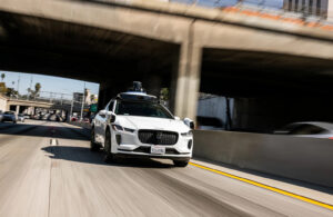 A Waymo vehicle driving on a freeway.